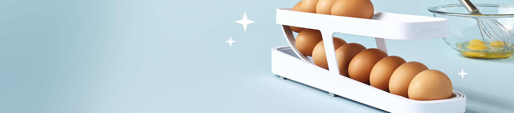 White egg holder with brown eggs on a light blue background