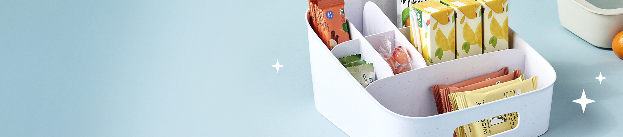 Organized storage basket with snacks on a blue background