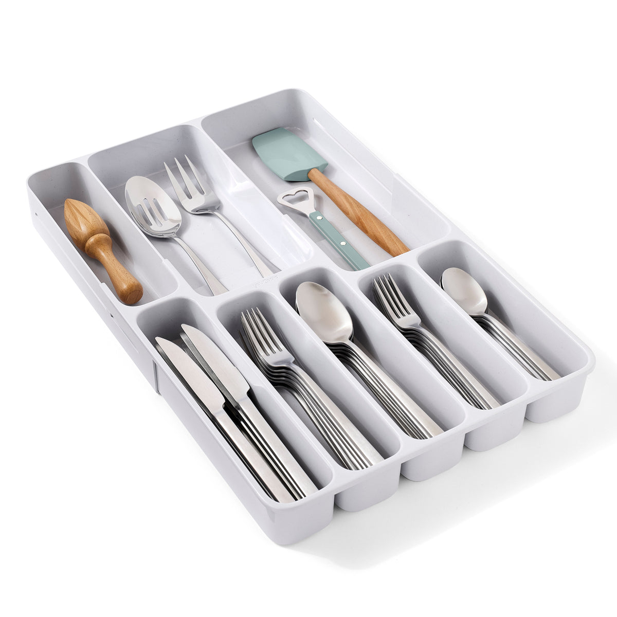 A white plastic cutlery organizer tray holding a flatware set with silver forks, spoons, knives, and utensils, plus two wooden-handled tools with a mint green silicone pad, on a white background.